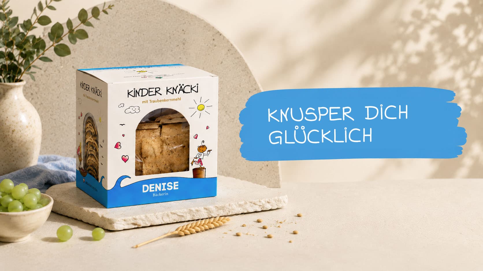 Kinder Knäcki Packung auf hellem Tisch mit Trauben und Getreide